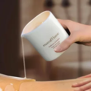 Close-up of a marocMaroc massage candle being poured over skin, warm melted wax as massage oil